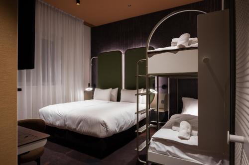 two bunk beds in a hotel room with two beds at You Hotel Budapest - Handwritten Collection in Budapest