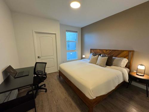 a bedroom with a bed and a desk with a laptop at Modern Retreat 10 Min from Disneyland With Pool & Gym in Tustin