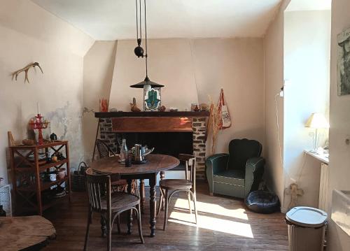 une salle à manger avec une table, des chaises et une cheminée dans l'établissement Chambre et b&b, à Miraval-Cabardès