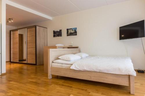 a bedroom with a bed and a flat screen tv at Easty Stay Apartments - City Centre in Tallinn