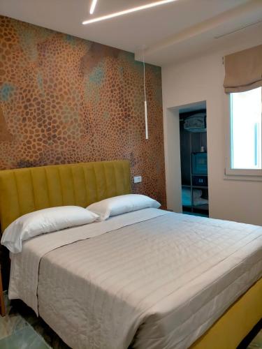 a bedroom with a large bed with a yellow headboard at Modus Boutique Hotel in Faenza