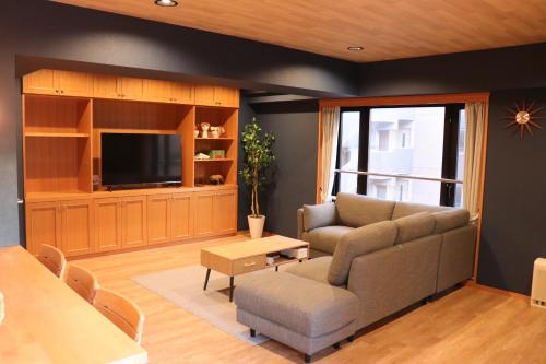 a living room with a couch and a tv at メゾン大通りパーク in Sapporo