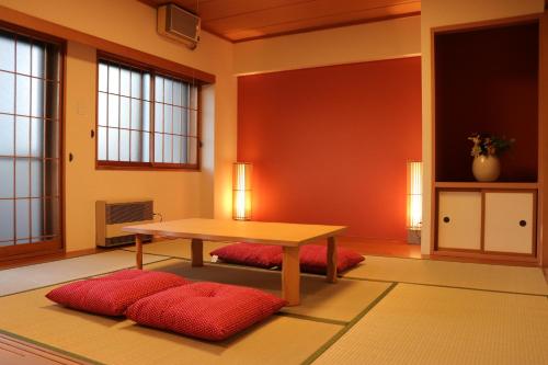 a room with a table and two red pillows at メゾン大通りパーク in Sapporo