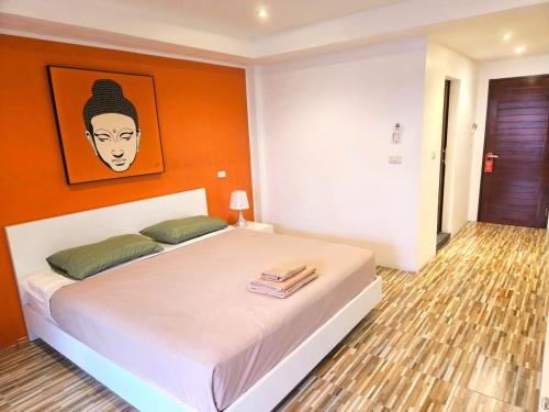 a bedroom with a bed with a painting on the wall at Al Fiore Guesthouse Pattaya in Pattaya South