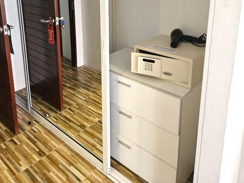 a door leading into a room with a microwave on a dresser at Al Fiore Guesthouse Pattaya in Pattaya South