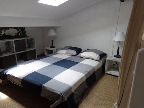 a bedroom with a blue and white bed with two lamps at Maisonnette - M04231 in Soulac-sur-Mer