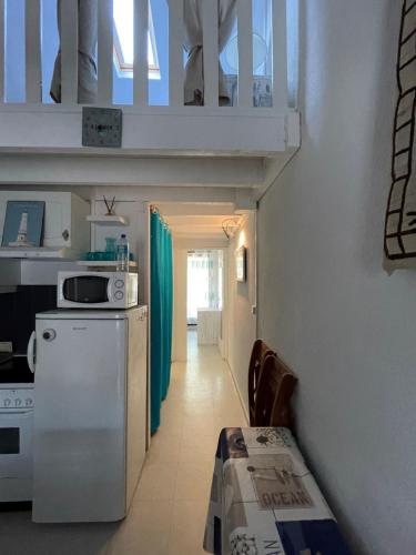 eine Küche mit einem weißen Kühlschrank und einem Tisch in der Unterkunft Maisonnette - M04231 in Soulac-sur-Mer