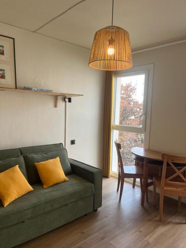 a living room with a green couch and a table at Studio meublé à Jonzac in Jonzac