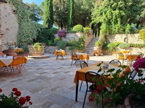 a patio with tables and chairs in a garden at Agriturismo Borghetto Il Montino in Rapolano Terme