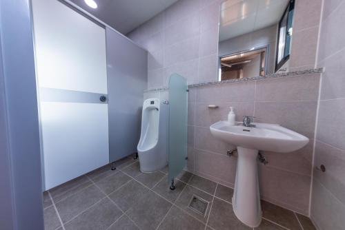 a bathroom with a sink and a urinal at Private Suncheon House in Suncheon