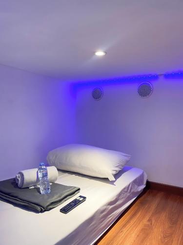 a bed in a room with a purple wall at Hotel Shakti Capsule in Bandung