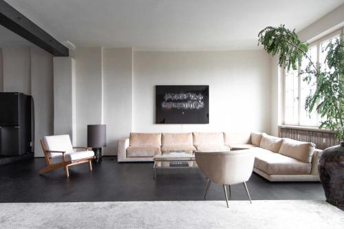 ein Wohnzimmer mit einem weißen Sofa und Stühlen in der Unterkunft Stadtflucht Homes in Berlin