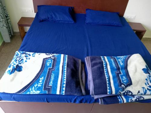DevaprayāgにあるKrishna Hotel & Restaurantのベッド(青いシーツ、青い枕付)