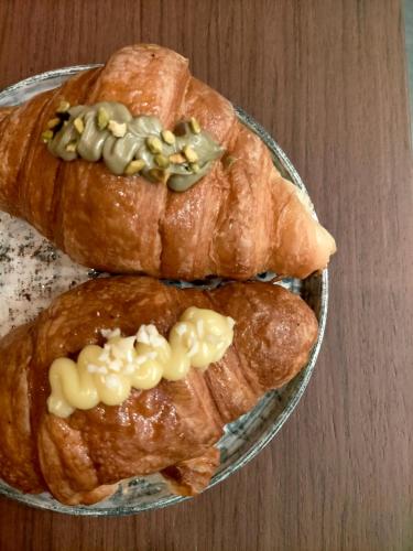 three croissants on a plate on a table at Modus Boutique Hotel in Faenza