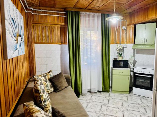 een woonkamer met een bank en een keuken bij SHoliday 1 Bedroom Balcony &Free Parking in Timişoara