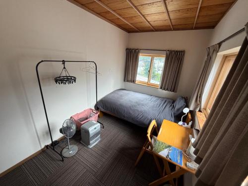 a bedroom with a bed and a desk and a chair at Nori's Sharehouse Hakuba in Hakuba