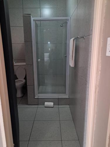 a bathroom with a shower and a toilet at Postmasburg Inn in Postmasburg