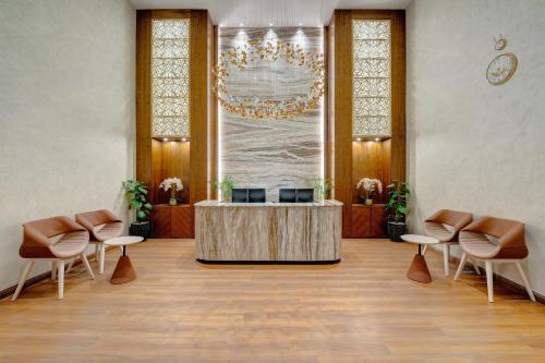 a lobby with a reception desk and chairs and a chandelier at Movenpick Hotel Centaurus Islamabad in Islamabad