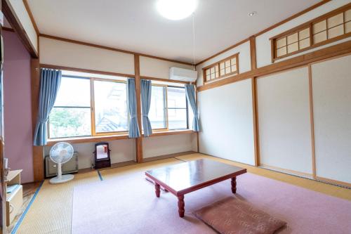 a living room with a table and a window at Lodge Matsuya in Nozawa Onsen