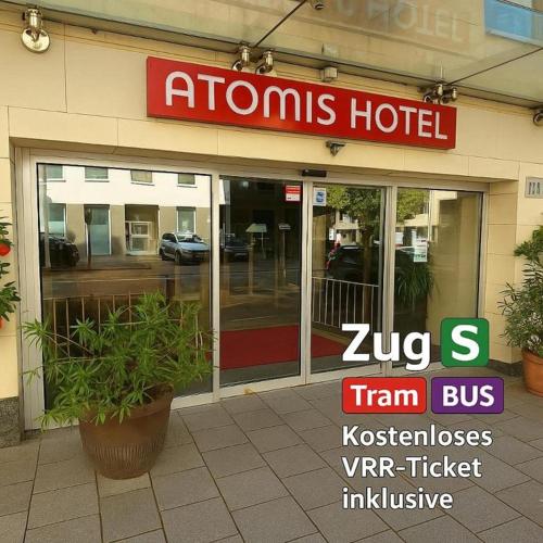 a hotel with a sign on the front of a building at Atomis Hotel Düsseldorf City in Düsseldorf