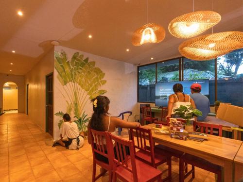 a group of people sitting at a table in a restaurant at Where Is Hostel - Koh Tao in Koh Tao