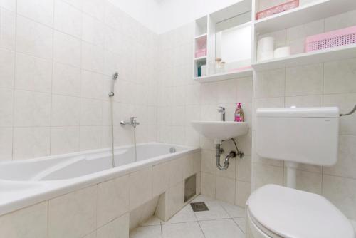 a bathroom with a tub and a toilet and a sink at House Pag Vacation House in Pag