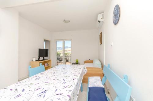 a white room with a bed and a clock on the wall at House Pag Vacation House in Pag
