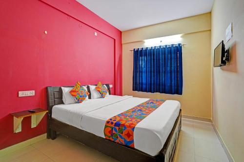 Un dormitorio con una cama grande con una pared roja. en Via SLV Suites, en Bangalore
