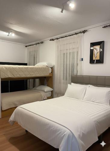 a bedroom with two bunk beds with white sheets at Bonito apartamento Cistierna in Cistierna