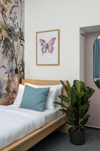 a bedroom with a bed and a potted plant at Hotel Botanica by Goodnite cz in Brno