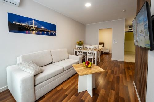 a living room with a white couch and a table at Wesoła Apartamenty in Wólka Kosowska