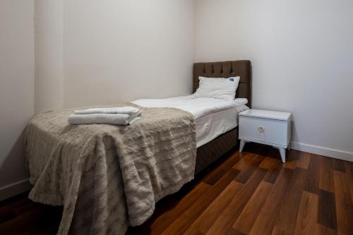 a small bedroom with a bed with a blanket on it at Wesoła Apartamenty in Wólka Kosowska