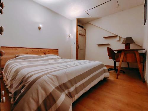 una camera da letto con un letto, una scrivania e un tavolo di La Maison Bleue a Brouvelieures