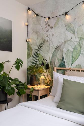 a bedroom with a bed and a table with plants at Hotel Botanica by Goodnite cz in Brno