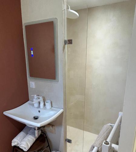 a bathroom with a sink and a glass shower at Songe de Clarté in Plouigneau