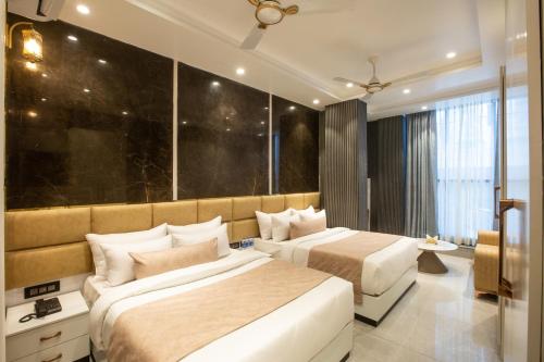a bedroom with two beds and a large window at Hotel Aroma Plaza Delhi Airport in New Delhi