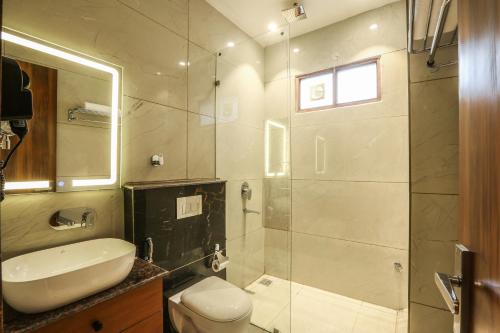 a bathroom with a toilet and a sink and a shower at Hotel Aroma Plaza Delhi Airport in New Delhi