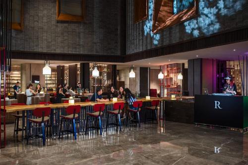 a bar with people sitting at tables in a restaurant at Renaissance Xi'an Hotel in Xi'an