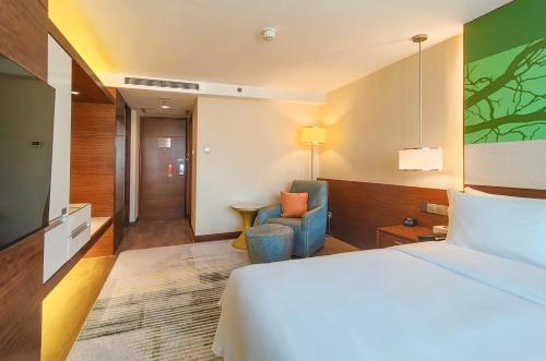 a hotel room with a bed and a chair at Holiday Inn Shenzhen Donghua by IHG in Shenzhen