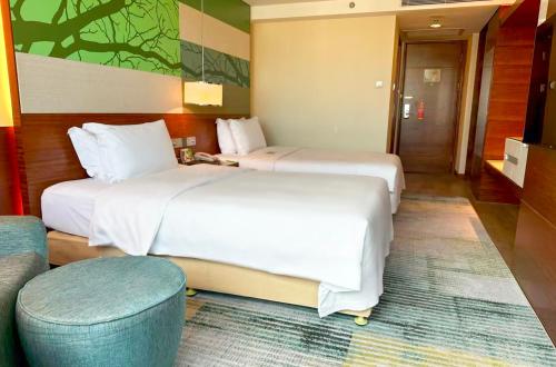 a hotel room with two beds and a couch at Holiday Inn Shenzhen Donghua by IHG in Shenzhen