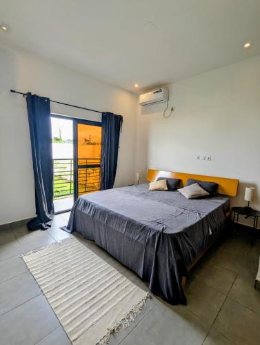 a bedroom with a bed and a large window at Villa le Baobab in Bikondo