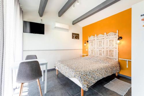 een slaapkamer met een bed en een tv aan de muur bij Studette Olivier in Les Taillades
