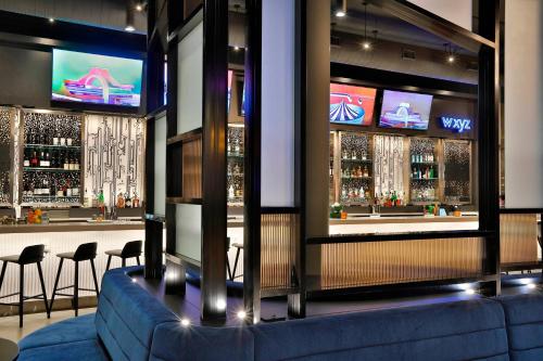 a bar with a blue couch in a room at Aloft Chicago Mag Mile in Chicago