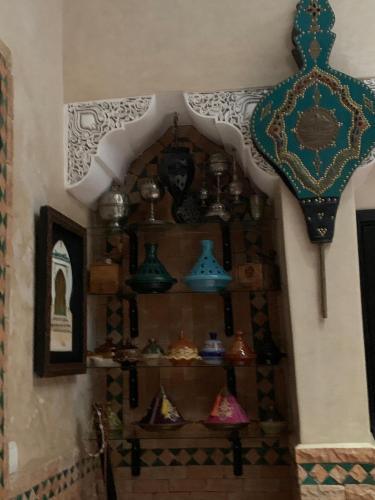 a room with a shelf filled with items on a wall at Dar Pa Labzioui in Meknès