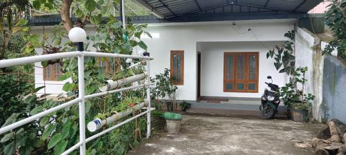 a house with a motorcycle parked in front of it at Aston Villa in Munnar
