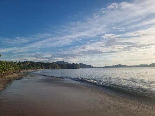 a beach with a body of water with mountains in the background at BlueStone Residence in Brasilito