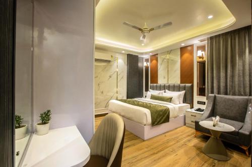 a bedroom with a bed and a living room at Hotel Aroma Plaza Delhi Airport in New Delhi