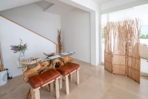 a dining room with a glass table and leather stools at Valentino Luxury Rooms in Porto Cesareo