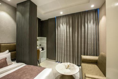 a bedroom with a bed and a couch and a table at Hotel Aroma Plaza Delhi Airport in New Delhi