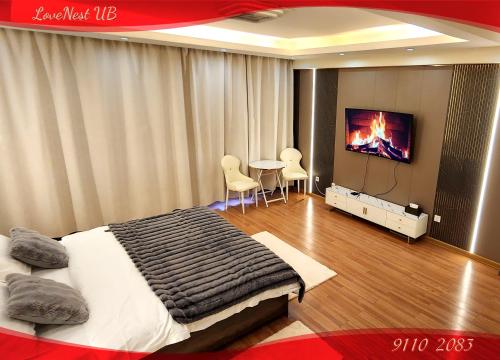 Un dormitorio con una cama, una mesa y un televisor. en LoveNest UB, en Ulán Bator